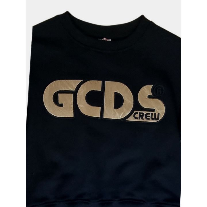 Dettaglio del maxi logo GCDS Crew color oro sul petto