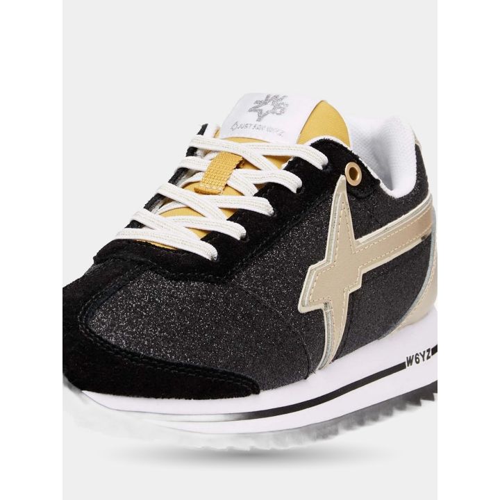 Dettaglio del logo oro metallizzato sul glitter nero e della punta in camoscio