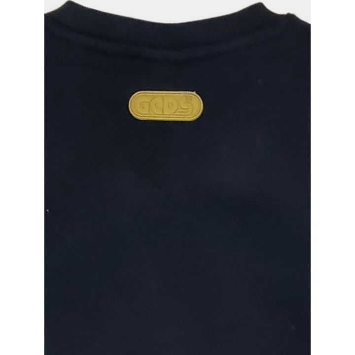 Dettaglio della placca gialla con logo GCDS sul retro del collo
