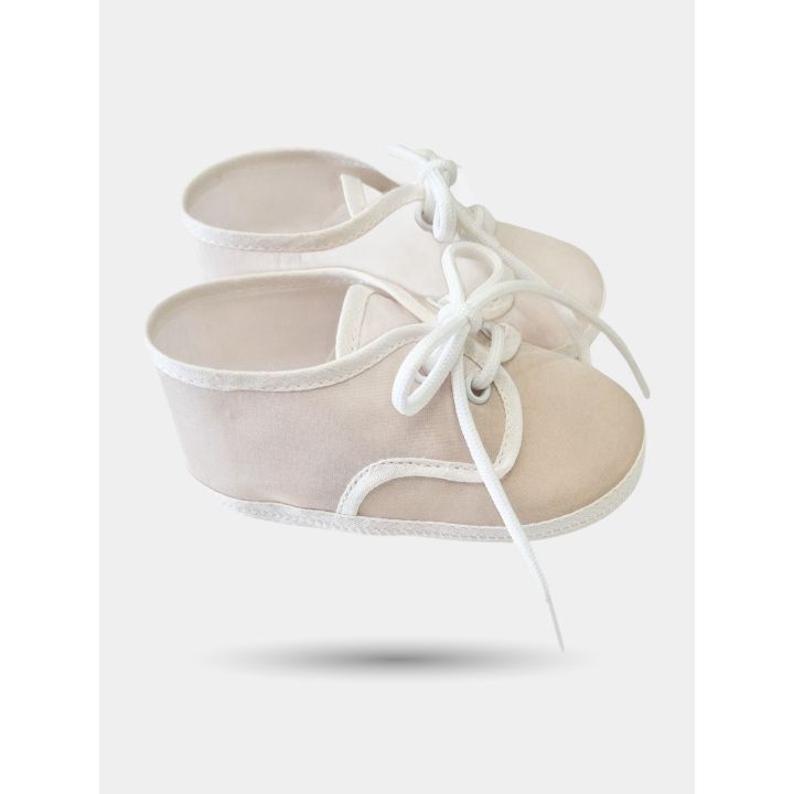 Scarpina beige di profilo con bordini e lacci bianchi