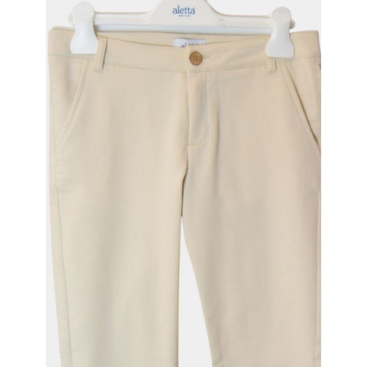 Dettaglio della vita dei pantaloni beige con bottone e passanti