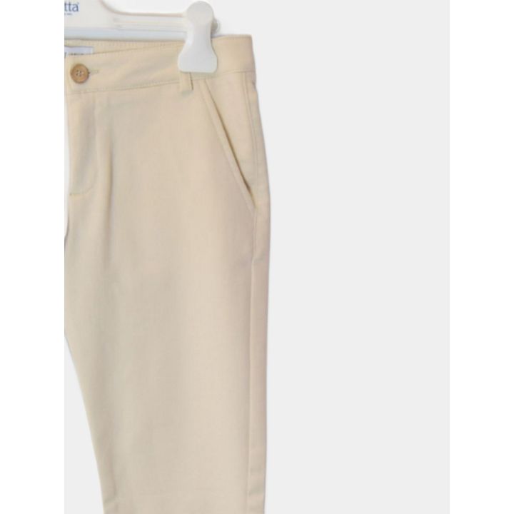 Pantaloni beige visti di tre quarti con il bottone color legno