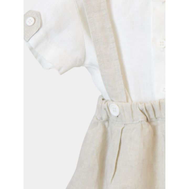 Dettaglio della manica con risvolto abbottonato e del pantaloncino beige