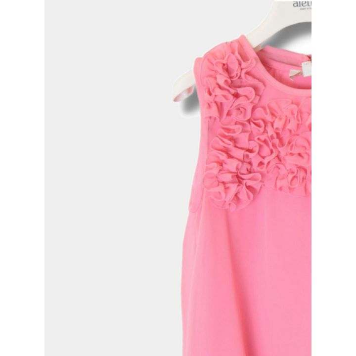 Vista laterale della blusa rosa con petali applicati