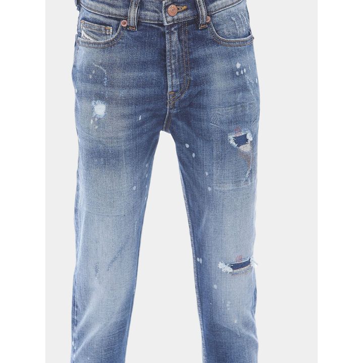 Dettaglio delle rotture con rammendi colorati sul jeans Diesel blu
