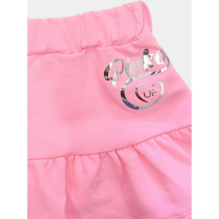 Dettaglio del logo Pinko Up argento a specchio sulla gonna rosa