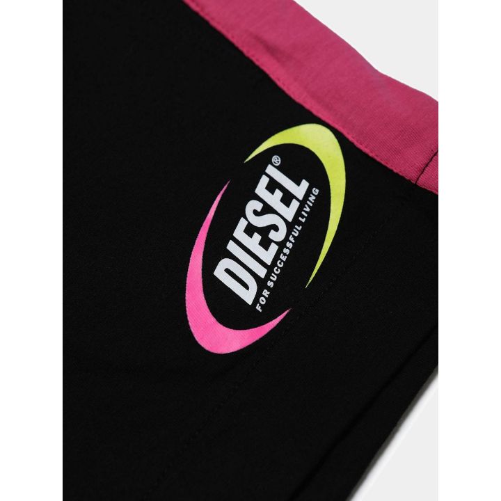 Dettaglio del logo Diesel vintage fucsia e giallo sugli shorts