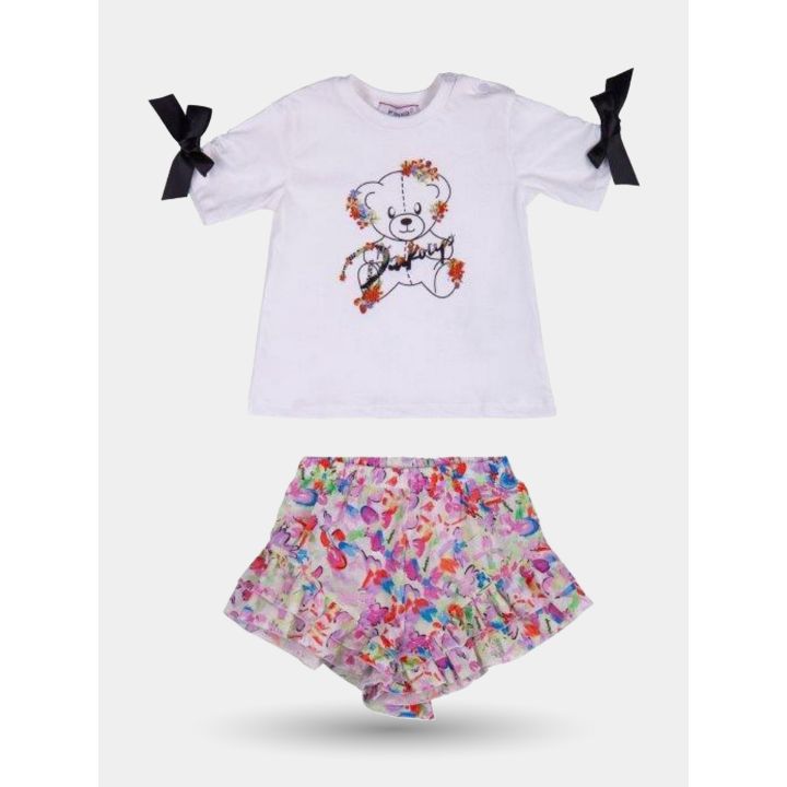 Completo Pinko con t-shirt bianca a fiocchi neri e pantaloncino a balze, vista frontale
