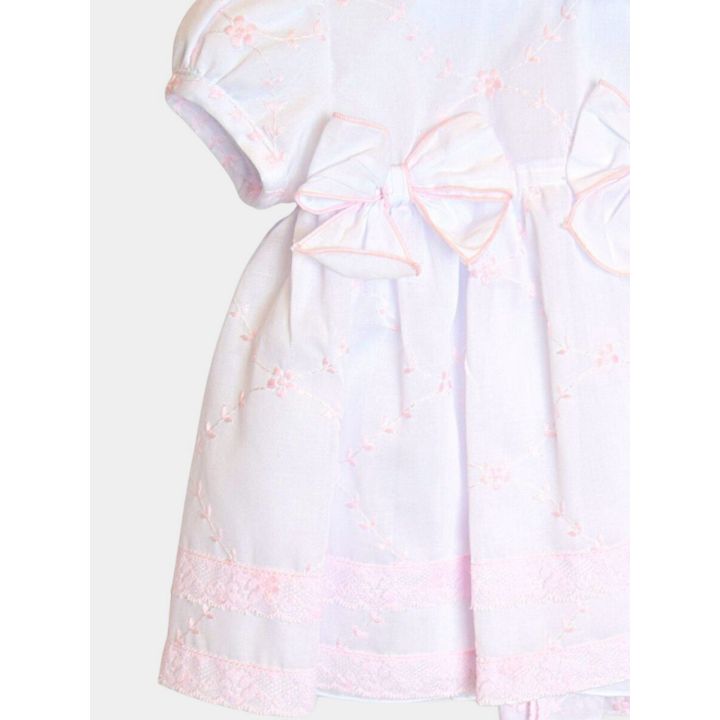 Vestito bianco Aletta visto di lato con la balza ricamata rosa