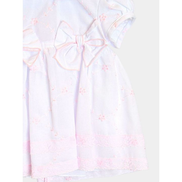 Dettaglio della gonna con ricami di fiorellini rosa e manica a palloncino