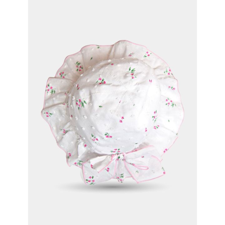 Cappello bianco a fiorellini visto dall'alto con falda arricciata bordata di rosa