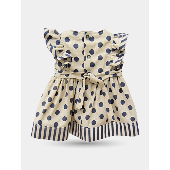 Retro del vestito beige a pois con bottoncini e cintura annodata