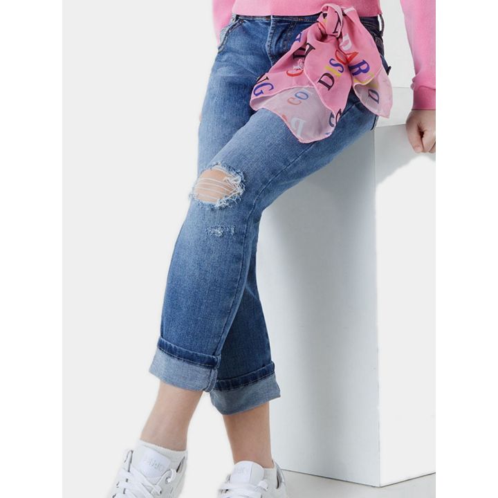 Ragazza seduta con i jeans Liu Jo strappati al ginocchio e foulard rosa