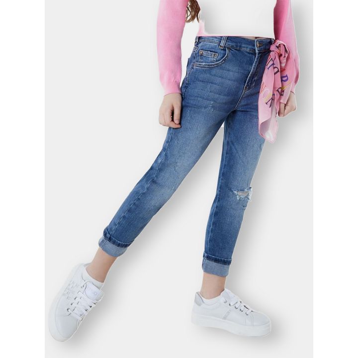 Ragazza con i jeans Liu Jo blu a gamba dritta con risvolto e sneakers bianche