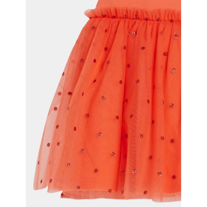 Dettaglio della gonna in tulle rosso con pois glitter