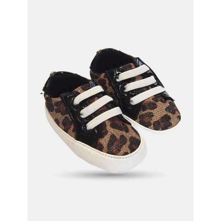 Sneakers maculate viste di tre quarti con lacci bianchi