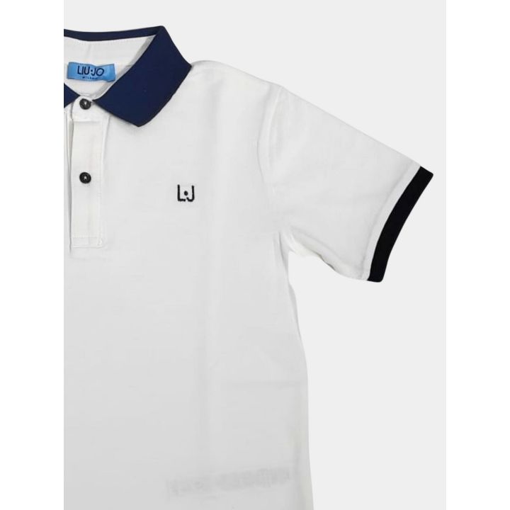 Dettaglio della manica corta con bordino blu della polo bianca
