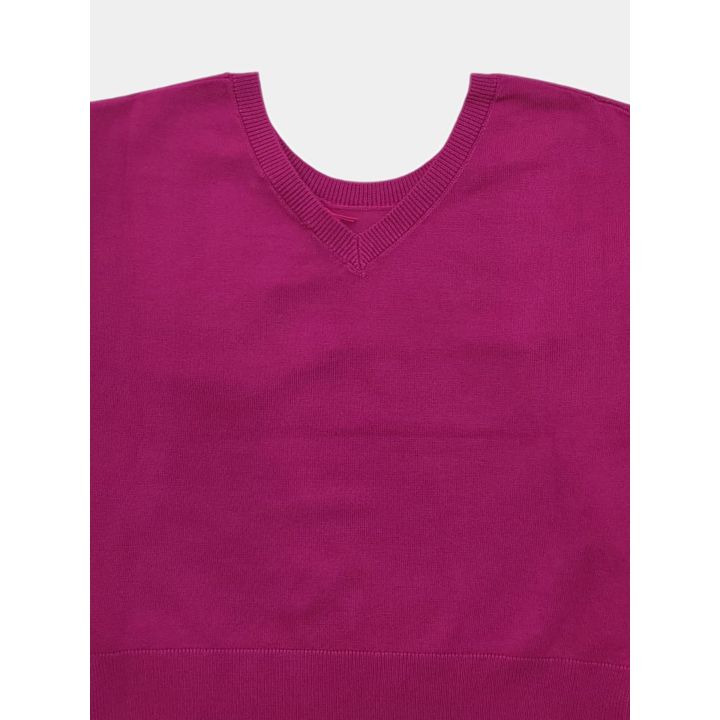 Dettaglio del motivo a V sotto lo scollo della maglia fucsia, sul retro
