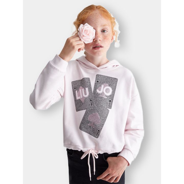 Ragazza con la felpa Liu Jo rosa con cappuccio e carte da gioco in brillantini