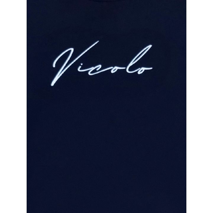 Dettaglio della scritta Vicolo bianca in corsivo sul petto della t-shirt blu