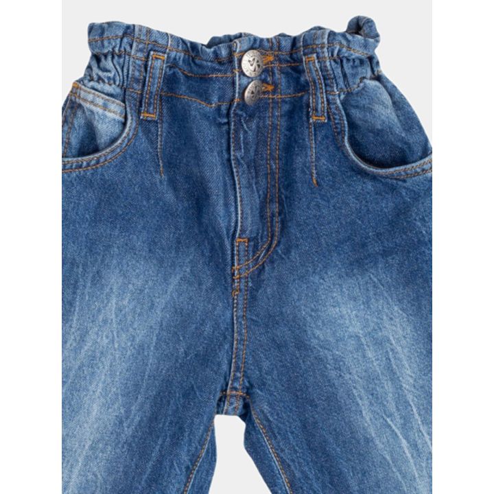 Dettaglio della vita arricciata elastica con i due bottoni del jeans blu