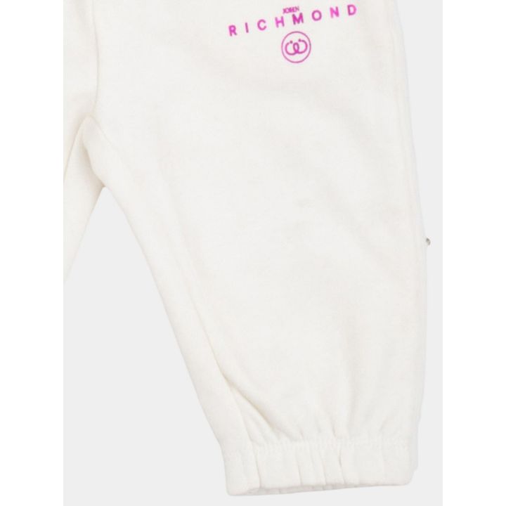 Dettaglio della gamba con logo fucsia e caviglia elastica dei pantaloni bianchi
