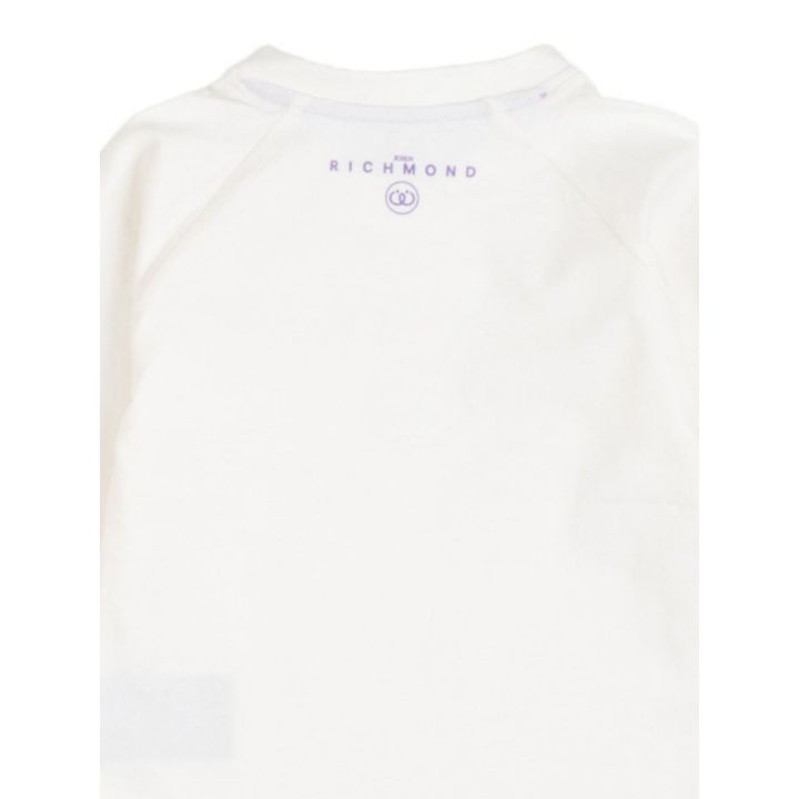 Dettaglio del logo lilla stampato dietro sotto il collo della t-shirt bianca