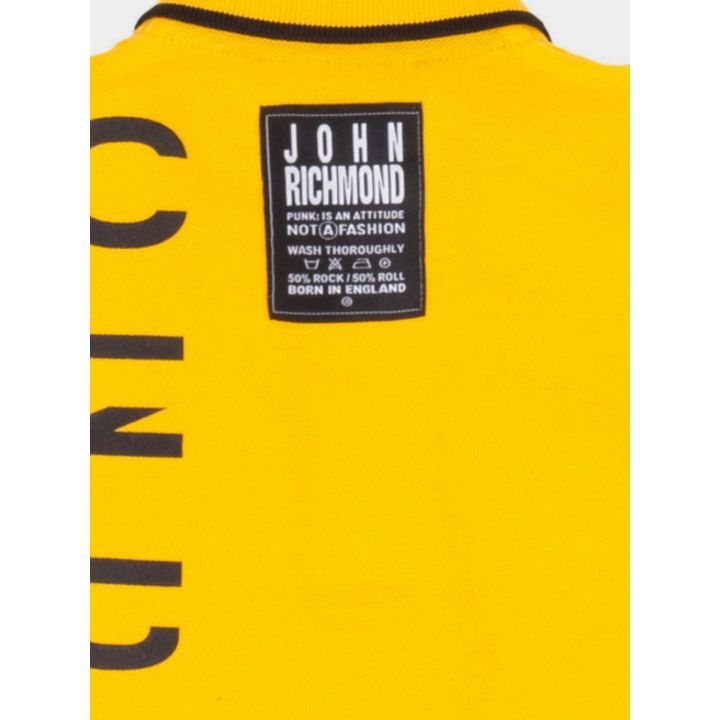 Dettaglio della patch nera John Richmond sul retro della polo gialla