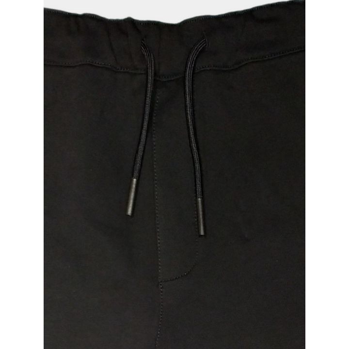 Dettaglio della coulisse con puntali sui pantaloni tuta neri
