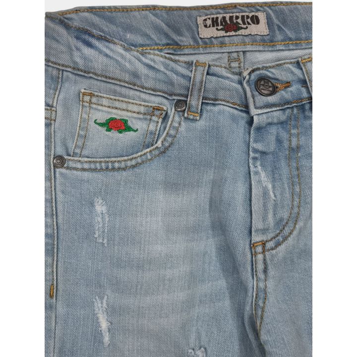 Dettaglio della rosa ricamata sul taschino dei jeans blu chiaro