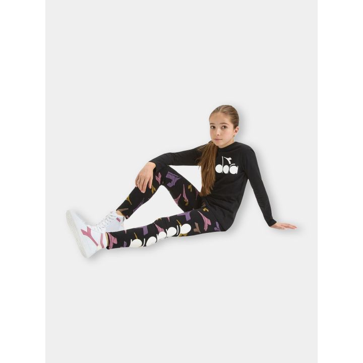 Bambina seduta a terra con i leggings Diadora neri a fantasia