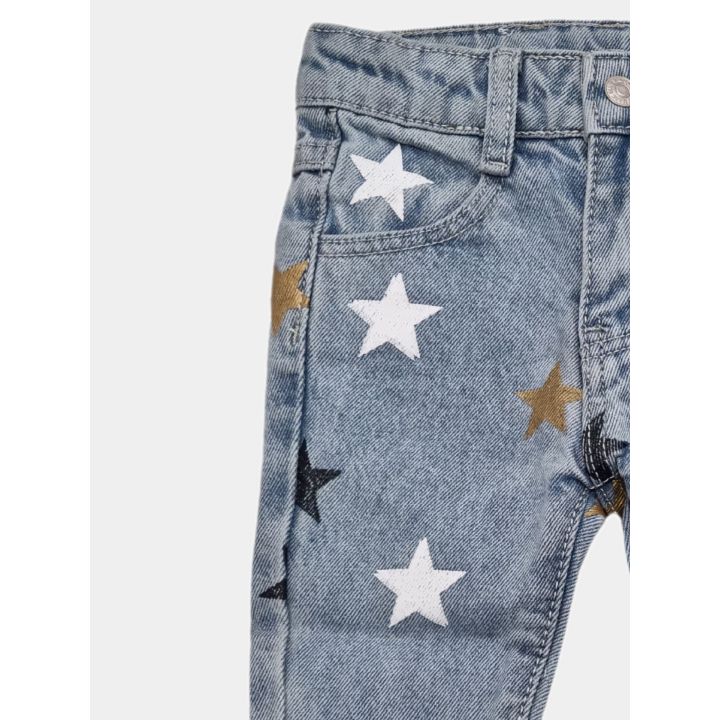 Dettaglio della gamba dei jeans con stelle bianche, blu e dorate
