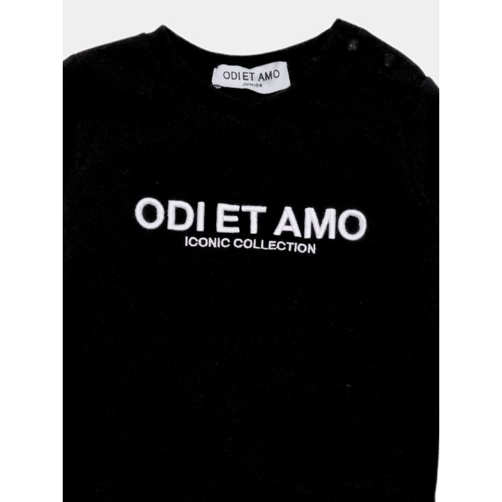 Dettaglio del logo Odi et Amo ricamato in bianco