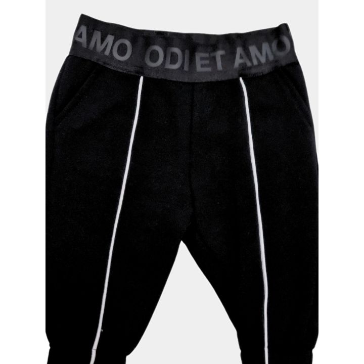 Dettaglio della tasca laterale e della riga bianca dei leggings neri