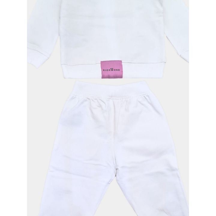 Dettaglio dell'etichetta lilla sul retro della maglia e del pantalone bianco