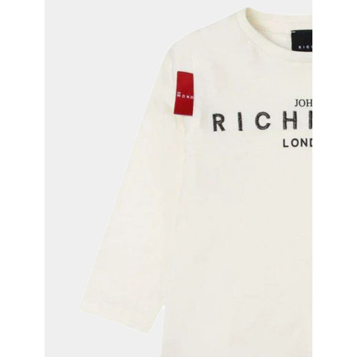 Dettaglio della manica con l'etichetta rossa della t-shirt bianca