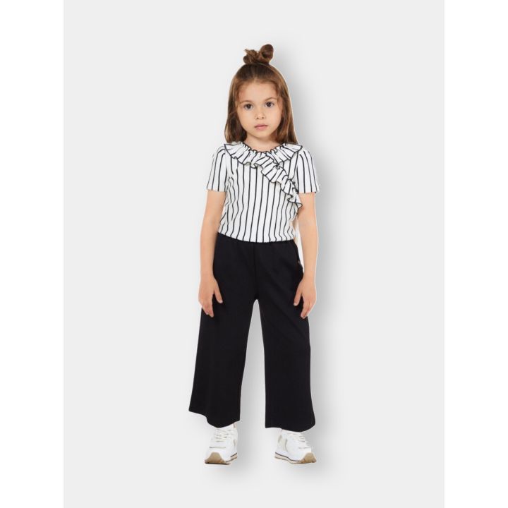 Bambina con l'abito tuta Liu Jo a righe e pantalone nero a gamba larga