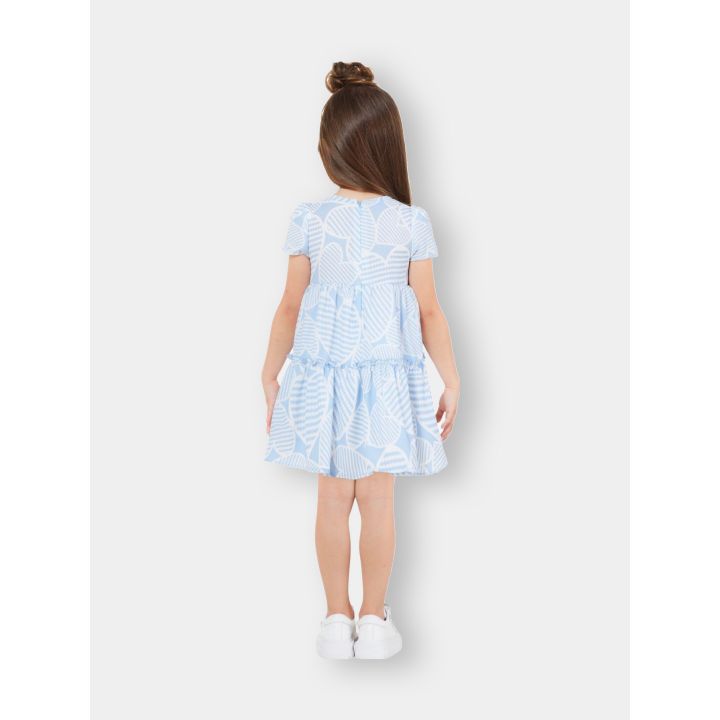 Bambina di spalle con l'abito a cuori celeste e bianco