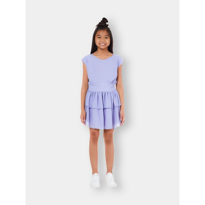 Ragazza con l'abito Liu Jo viola lavanda a balze e sneakers bianche