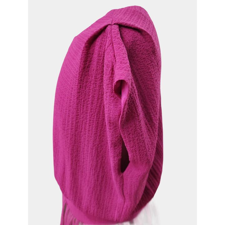 Dettaglio della manica ad aletta dell'abito fucsia, vista di lato