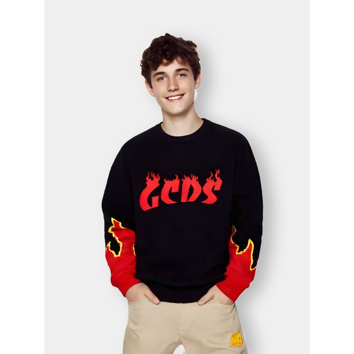 Maglione GCDS nero indossato da un ragazzo con logo e fiamme rosse