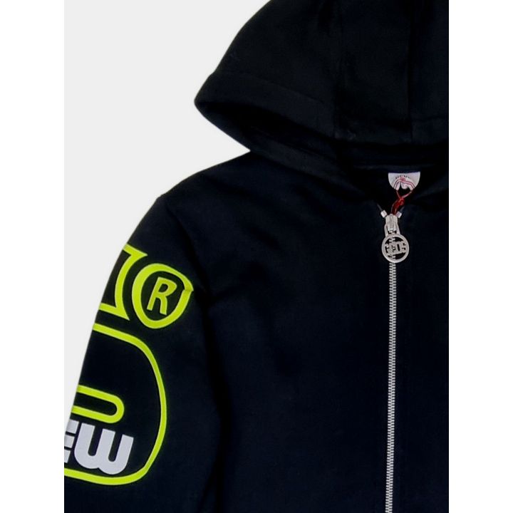 Dettaglio della manica con logo Crew giallo e tiretto a medaglione GCDS