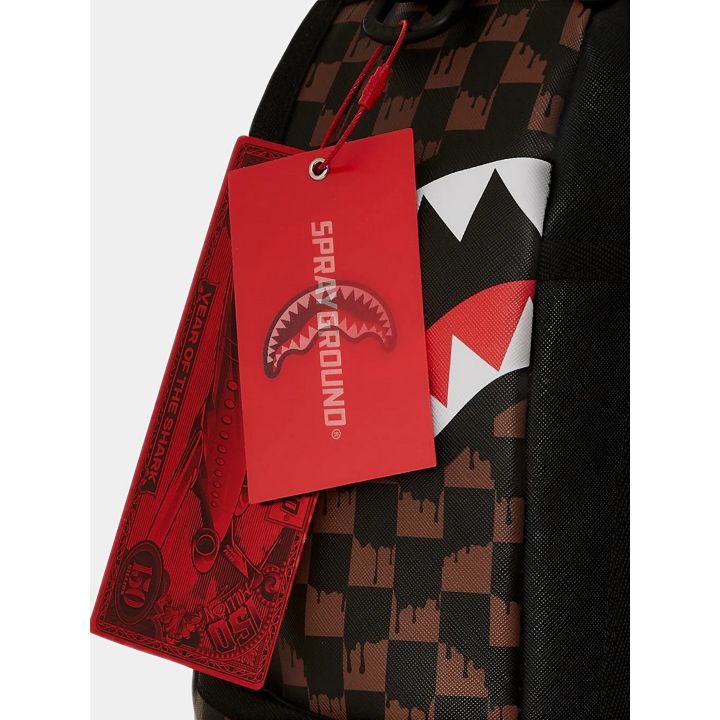Dettaglio del cartellino rosso Sprayground sugli scacchi marroni