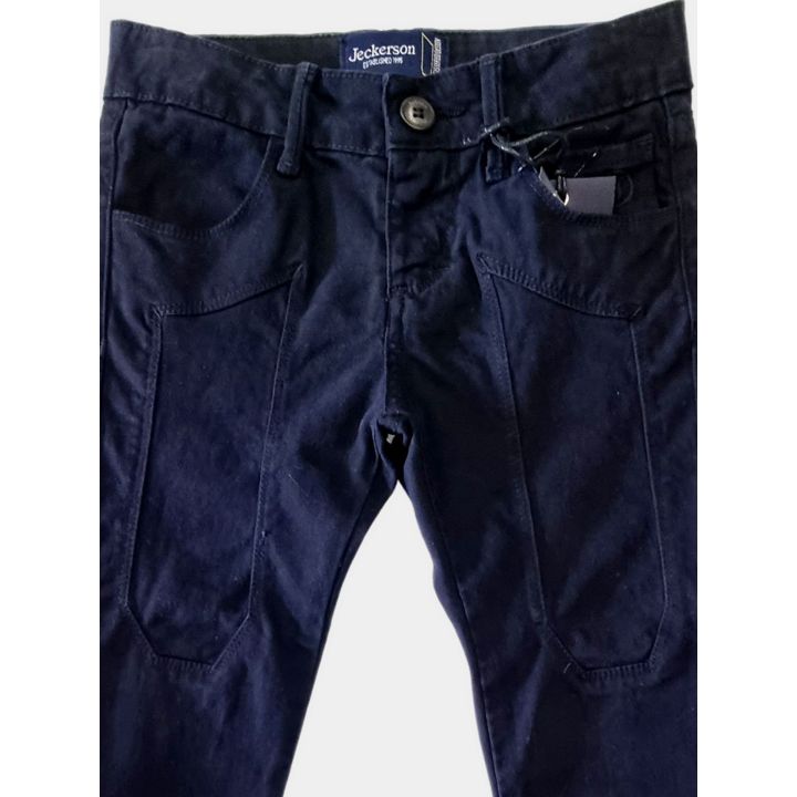 Dettaglio delle toppe tono su tono sul davanti dei pantaloni blu