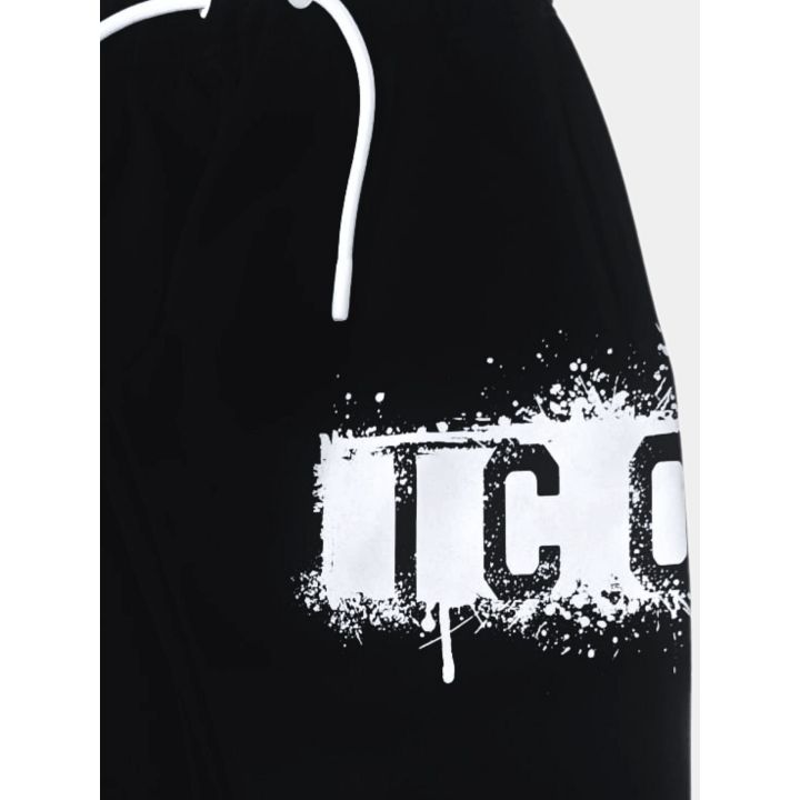 Dettaglio del pantalone nero con coulisse bianca e logo effetto spray