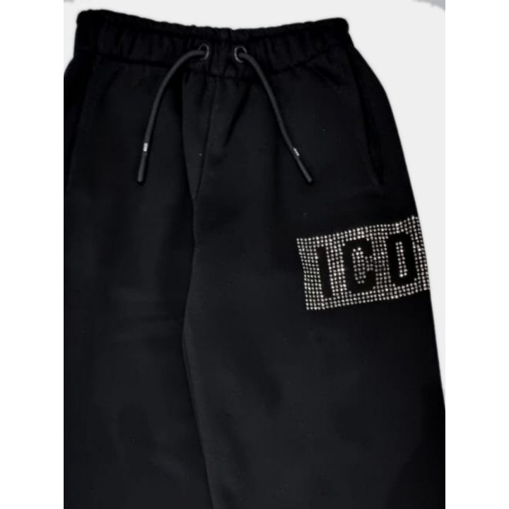 Dettaglio della vita con coulisse e del logo in strass sul pantalone