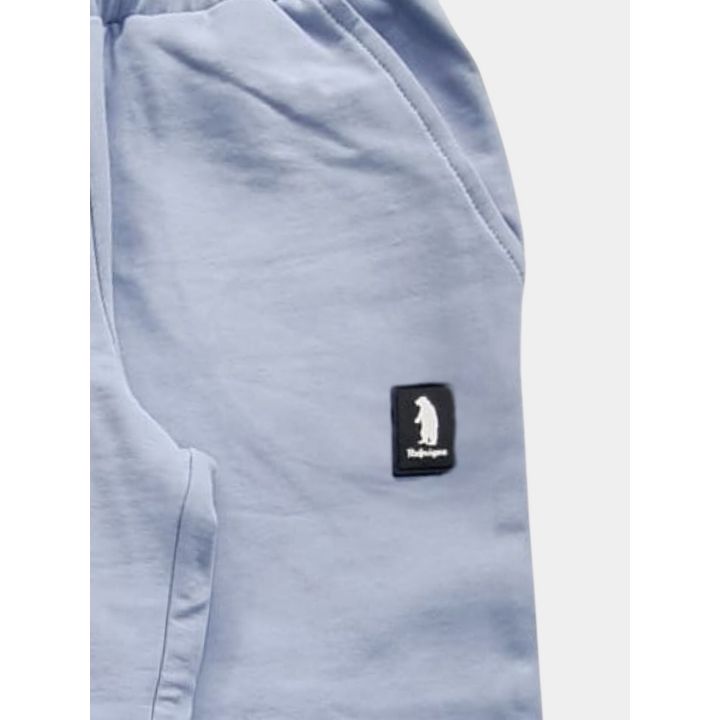 Dettaglio del pantalone celeste con tasca e patch Refrigue sulla gamba