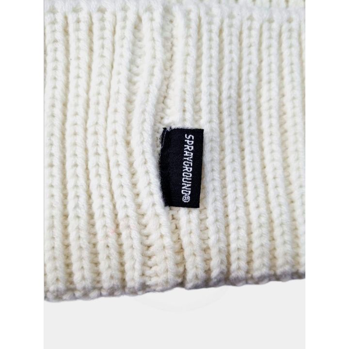 Dettaglio dell'etichetta nera Sprayground sulla maglia a coste