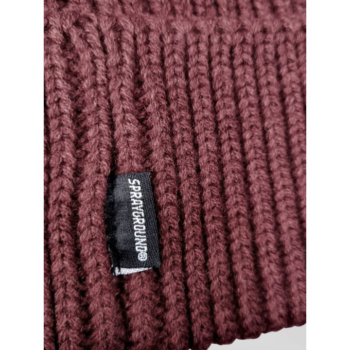 Dettaglio dell'etichetta Sprayground sulla maglia a coste bordeaux