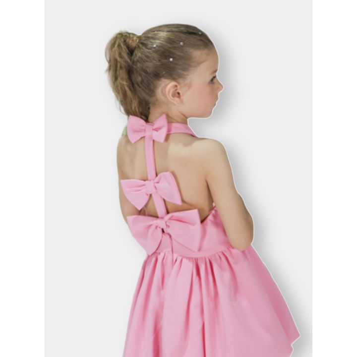 Bambina di spalle con l'abito fucsia e i tre fiocchi sul retro
